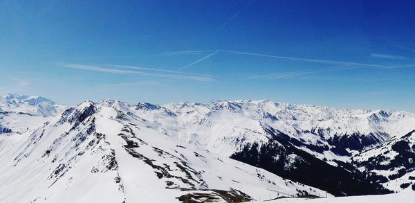 Scenic view of snowcapped mountains against blue sky