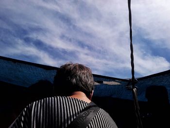 Rear view of man on mountain against sky