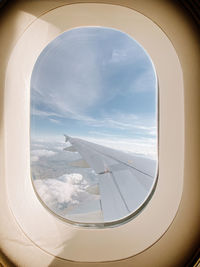 Aerial view of cloudy sky seen through airplane window