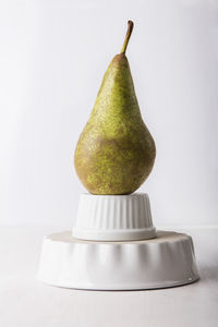 Close-up of pear on table against white background