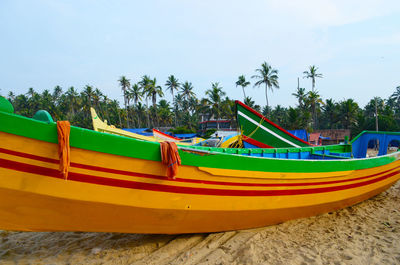 Boat moored on beach against sky