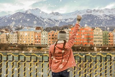 Man standing against buildings in city during winter