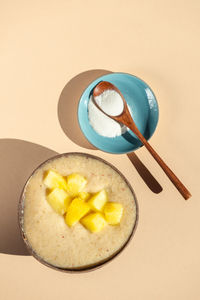 Collagen powder and smoothie from banana, pineapple and gluten free oats in the coconut shell bowl,