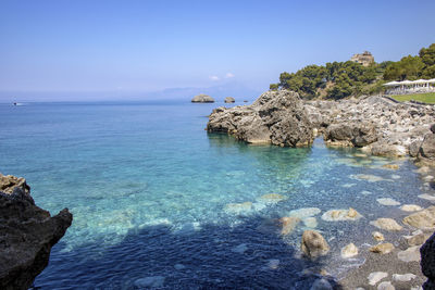 Scenic view of rocks in sea against sky