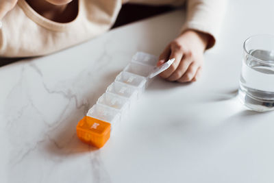 Midsection of woman holding dentures