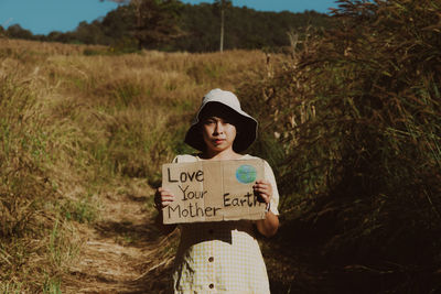 Portrait of young woman standing on field