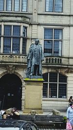 Statue against building in city