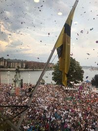 Crowd in city against sky