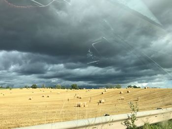 Scenic view of agricultural field against storm clouds