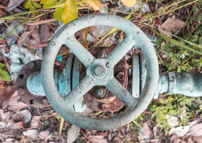 Close-up of rusty machine part on field