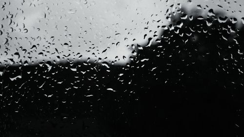 Close-up of wet glass window in rainy season