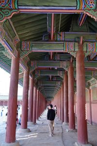 Rear view of woman walking in corridor of building