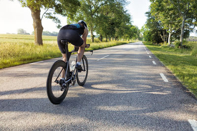 Woman cycling on country road