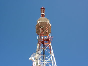 Low angle view of communications tower against clear blue sky