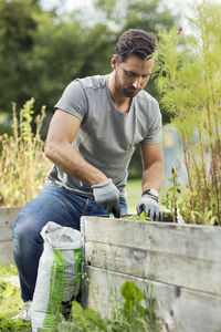 Mid adult man planting in community garden