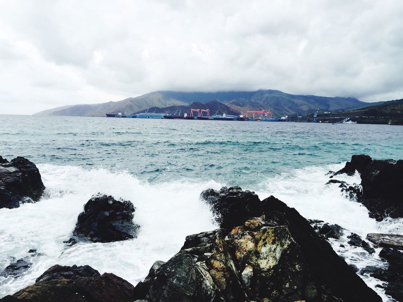 water, mountain, sea, sky, scenics, cloud - sky, beauty in nature, rock - object, cloudy, nature, tranquil scene, rock formation, wave, mountain range, weather, tranquility, surf, cloud, shore, idyllic