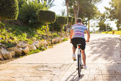 Rear view of man riding bicycle