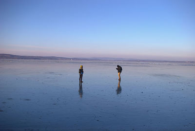 People on beach against sky