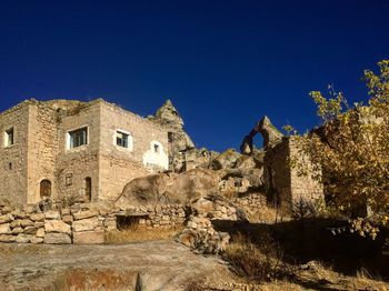 Low angle view of old ruin against clear blue sky