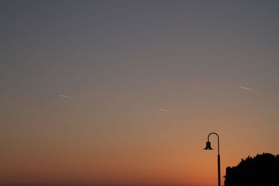 Silhouette of street light against clear sky