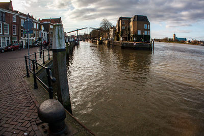 Canal amidst buildings in city against sky
