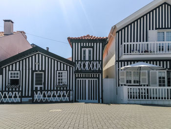 Houses by street in city against sky