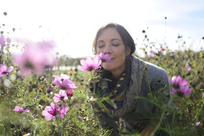 Portrait of women smelling on wild flower, flower meadow