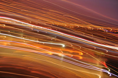 Light trails on road against sky at night