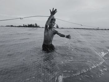 Fishing net on sea against sky