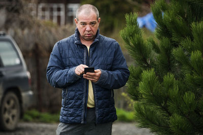 Portrait of man standing against plants