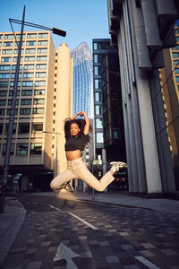 Woman standing by modern buildings in city