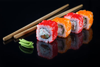 Close-up of sushi served on black background