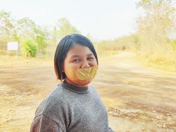 Girl with bandage on mouth standing on land