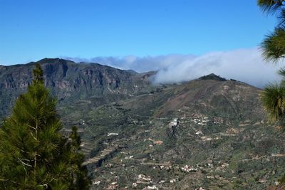 Scenic view of landscape and mountains against blue sky