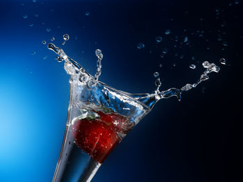Close-up of water drops on glass against blue background