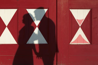 Shadow of kissing couple on red door