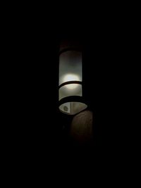 Low angle view of illuminated light bulb in dark room