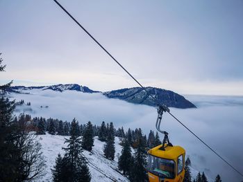 Overhead cable car against snowcapped mountains during winter