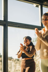 Happy women clapping during yoga class at retreat center