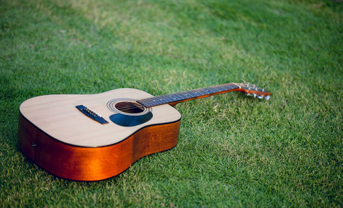 Close-up of guitar on grassy field