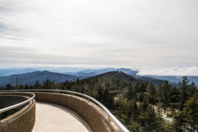 Scenic view of mountains seen from bridge against cloudy sky