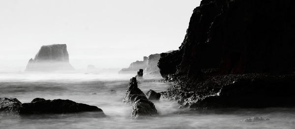 Rock formations by sea against sky