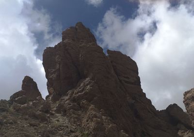 Low angle view of mountain against cloudy sky