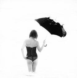 Rear view of woman with umbrella on beach