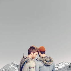 Rear view of couple kissing against clear sky