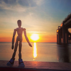 Full length of man standing on beach during sunset