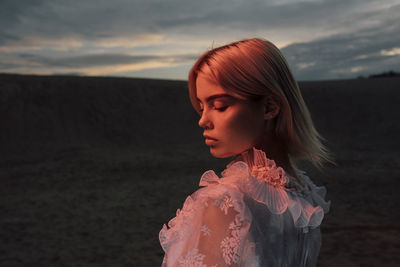 Portrait of a beautiful woman in a dress at sunset