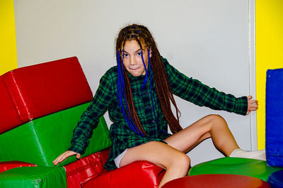 Young woman sitting on sofa at home