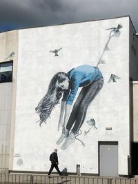 Full length of women standing against wall in city