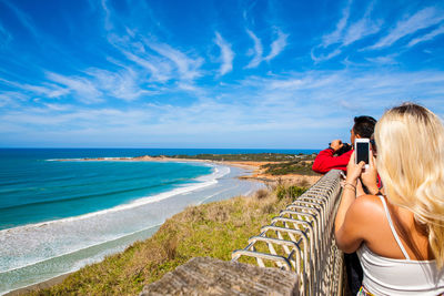 Rear view of woman looking at sea against sky